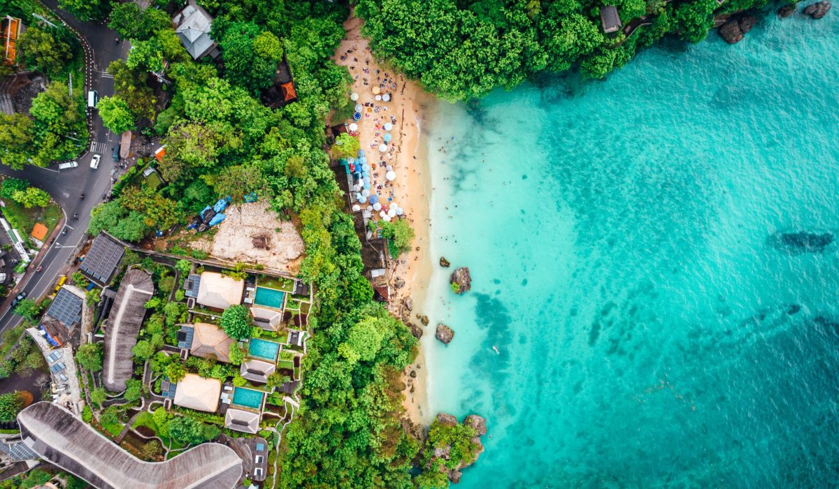 An aerial view of a luxurious coastal resort located on a sunny beach of a tropical island in Indonesia