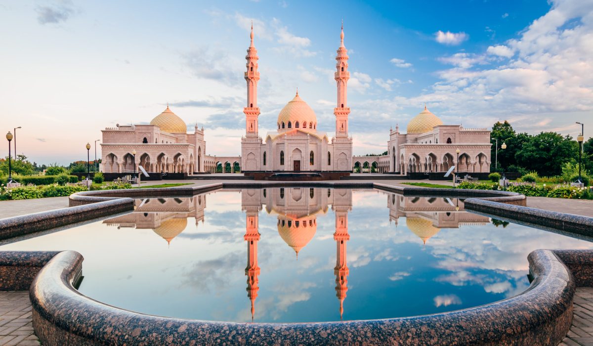 Beautiful White Mosque with Domes and Minarets at Sunset Light. Reflection on Water Surface. Bolghar, Rusiia.