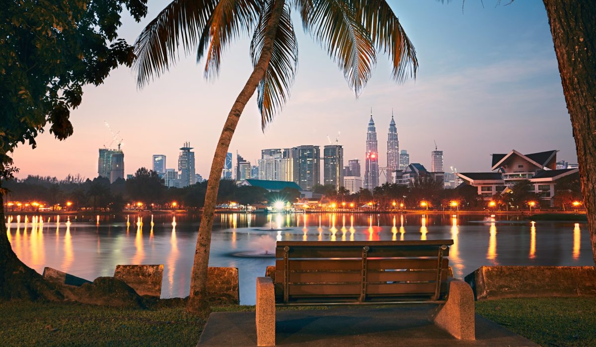 Beautiful morning in public park in Kuala Lumpur. Skyline of the modern city at sunrise.