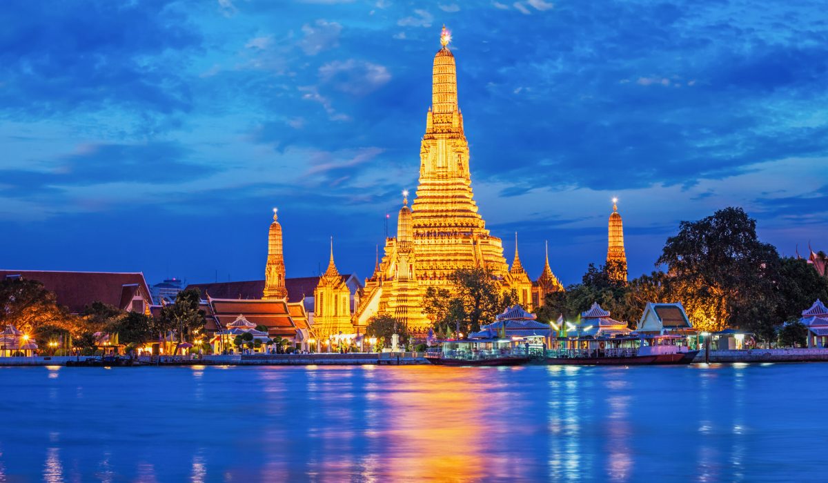 Buddhist temple Wat Arun (Wat Arun Ratchawararam Ratchawaramahawihan - Temple of Dawn) famous tourist landmark illuminated in the evening. Bangkok, Thailand